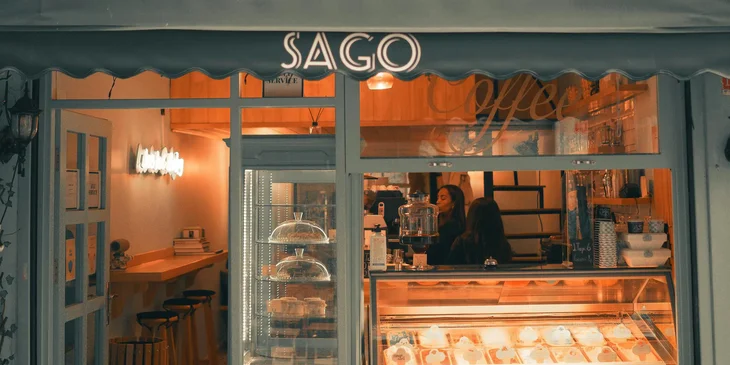 Fachada de una cafetería, con el nombre SAGO al frente.