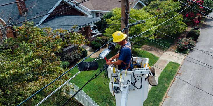 Electricista dando mantenimiento a cables eléctricos en un logo de electricista.