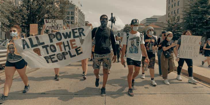 Un grupo de personas marchando y sosteniendo letreros con mensajes empoderados.