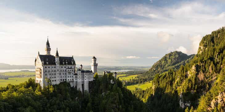 Ein episches Schloss, das majestätisch auf einem Berg thront und von einem Wald umgeben ist.
