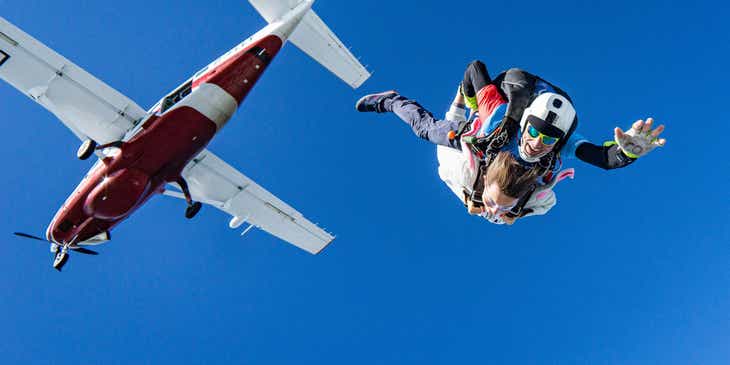 Two people participating in the extreme sport of skydiving.