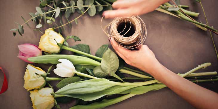 Tulpen und Rosen werden in einem Blumenladen zu einem Strauß zusammengestellt.