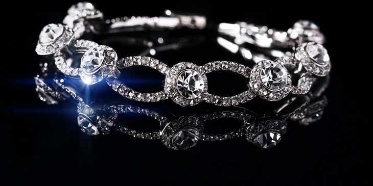 Uma glamourosa pulseira de diamantes em uma superfície preta.