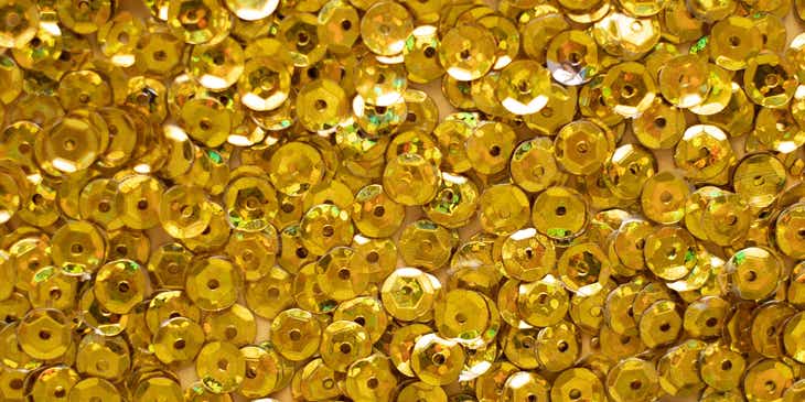 Un fondo lleno de lentejuelas doradas en un negocio con logo dorado.