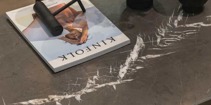 Un magazine et un luminaire posés sur une table en granite gris.