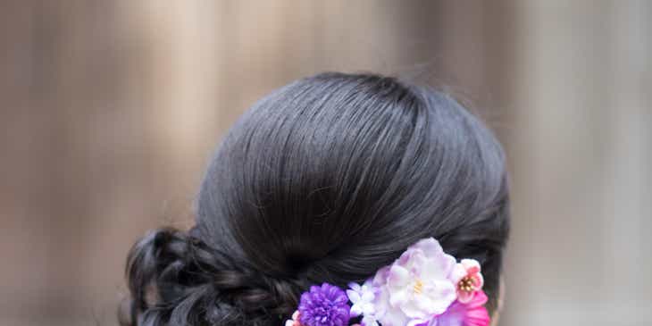 Renkli ve çiçekli bir saç aksesuarı takan bir kadın.