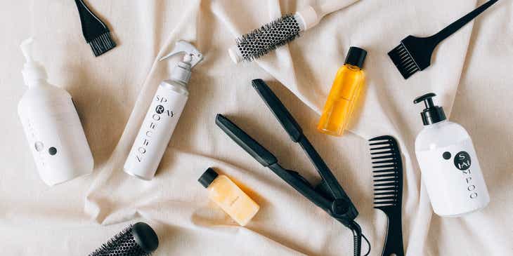 A variety of hair products displayed on a white sheet.