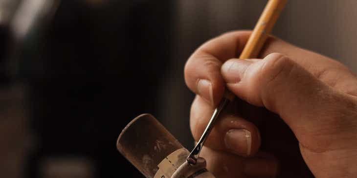 Een persoon die bezig is een handgemaakt sieraad te maken.