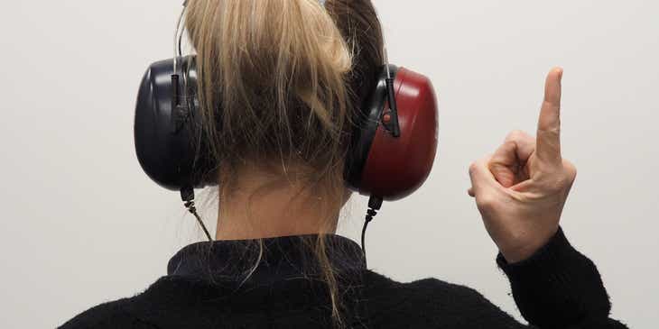 Una persona de espaldas con audífonos.