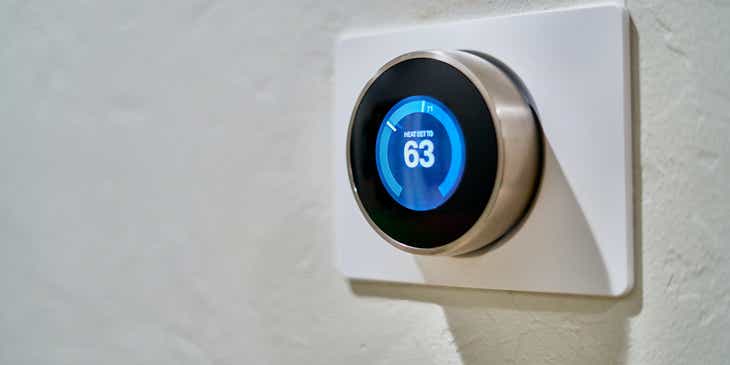 Das digitale Thermostats eines modernen Heiz- und Kühlsystems zeigt 63 Grad Fahrenheit an.