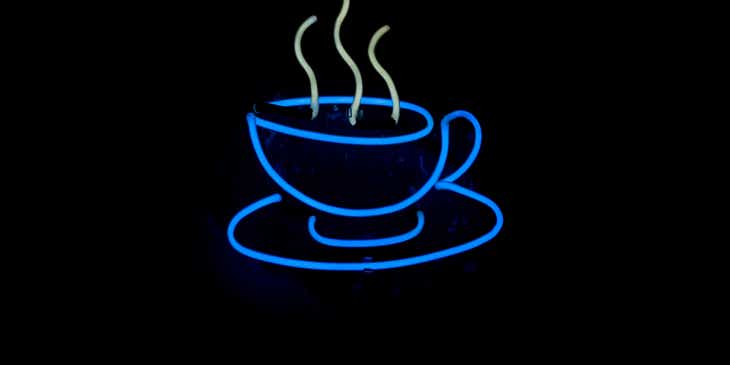 A steaming hot cup of coffee in neon lights.