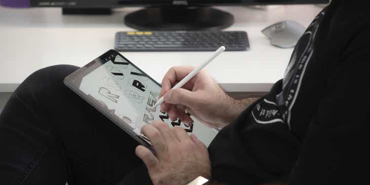 Una persona che disegna un logo su un tablet.