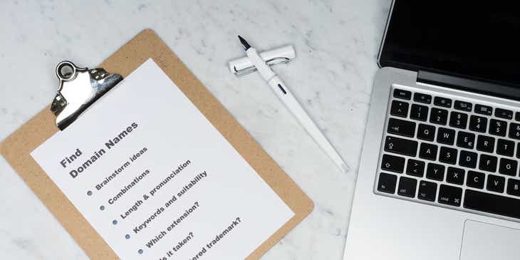 A clipboard next to a laptop with a page titled "Find Domain Names."