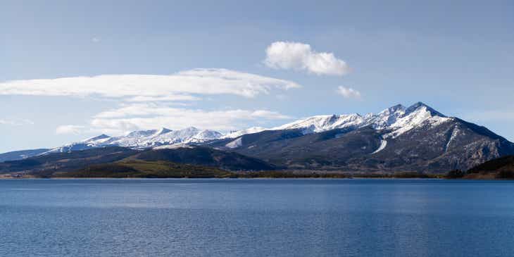 Snow-covered mountains surrounded by a body of water in Colorado.