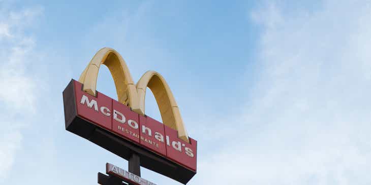 McDonald's franchise sign against blue sky with clouds