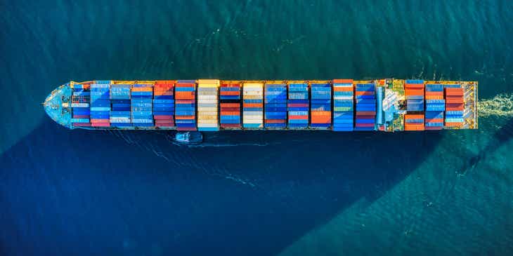 La vista aérea de un buque de carga que transporta mercancías en un logo para importadoras y exportadoras.
