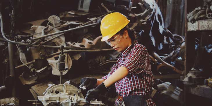 Una persona que arregla el motor de un vehículo en un logo industrioso.