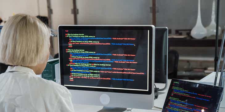 Un informático del área de IT trabajando con dos computadoras.