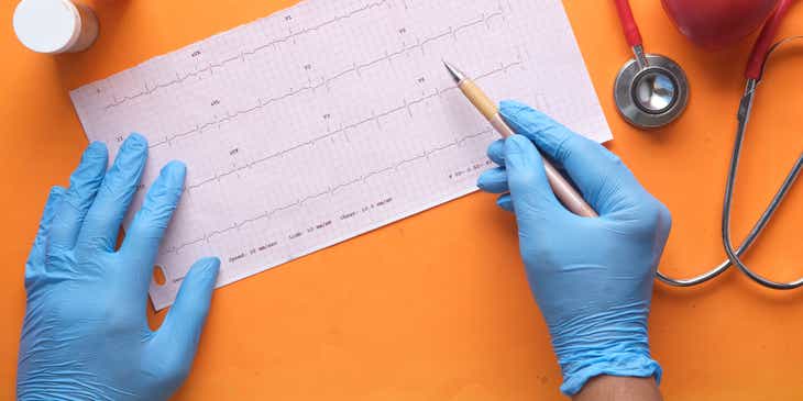 Bir kağıtta yer alan kalp ritim hızı verilerini inceleyen bir kardiyolog.