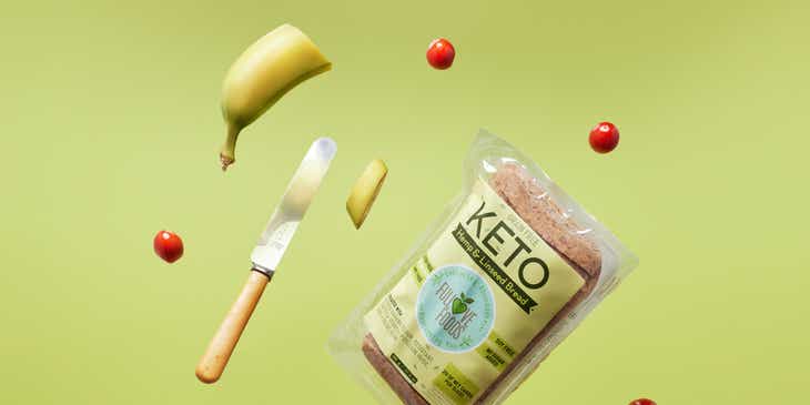 A person tossing a packet of keto bread and fruit in the air.