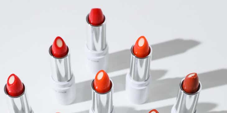 Des rouges à lèvres de différentes couleurs exposées sur un fond blanc.