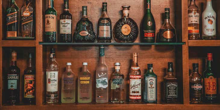 Bottles of liquor on a wooden shelf.