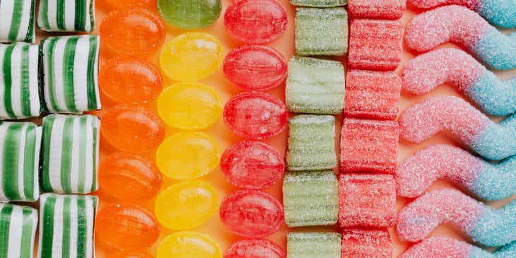 Tanti dolci e caramelle di colori diversi disposti in fila.