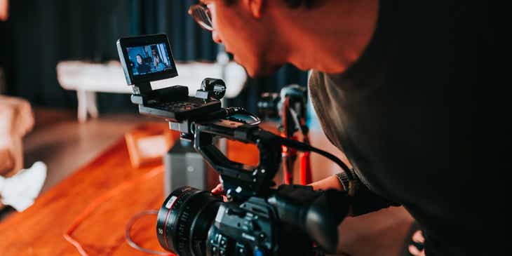 Un videomaker di una casa di produzione di video al lavoro mentre registra e dirige un video.