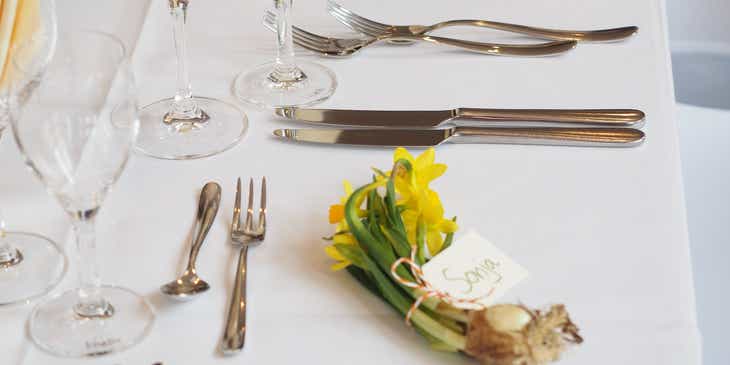 Berbagai alat makan diletakkan di atas meja putih.