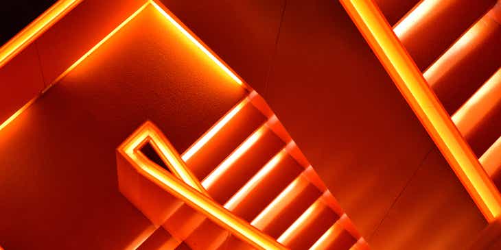 Una escalera iluminada en color naranja.