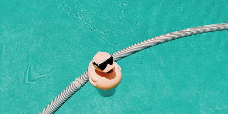 un patito con lentes de sol chidos en una piscina.