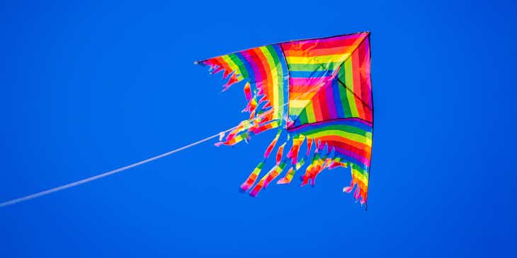 Una cometa voladora decorada con los colores del arco iris.