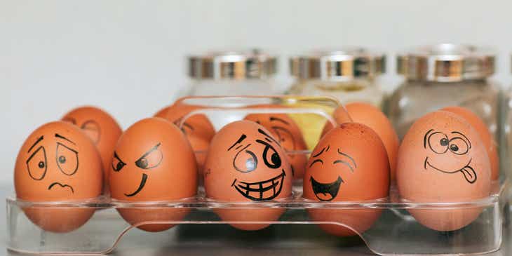 Huevos en un recipiente con caras divertidas dibujadas en ellos en un logo de huevo.
