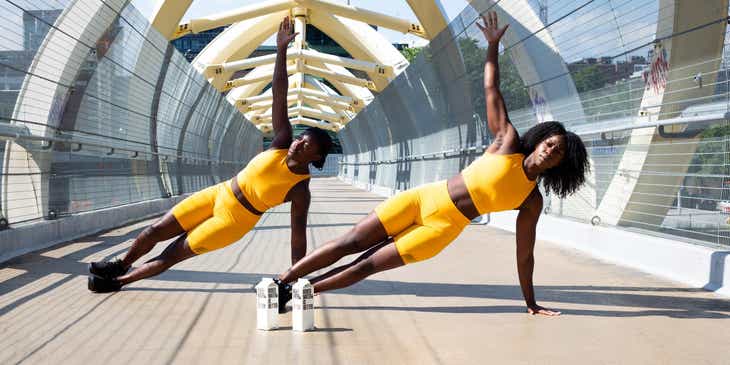Dos mujeres haciendo ejercicio en un conjunto de color amarillo en un logo par fitness.