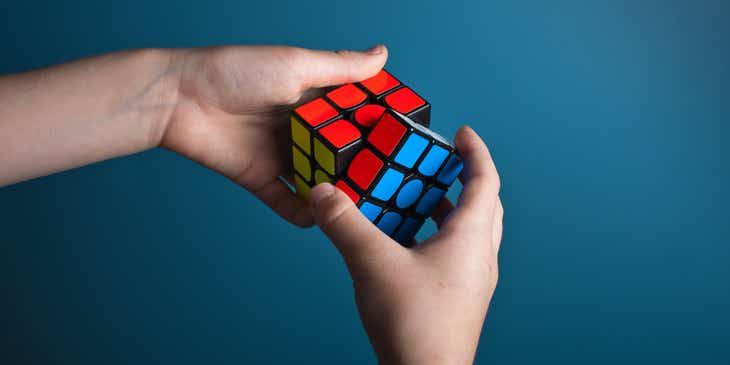 Un hombre inteligente resolviendo un cubo de Rubik en un negocio con nombre inteligente.