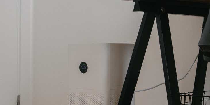 Un purificador de aire colocado junto a un escritorio.