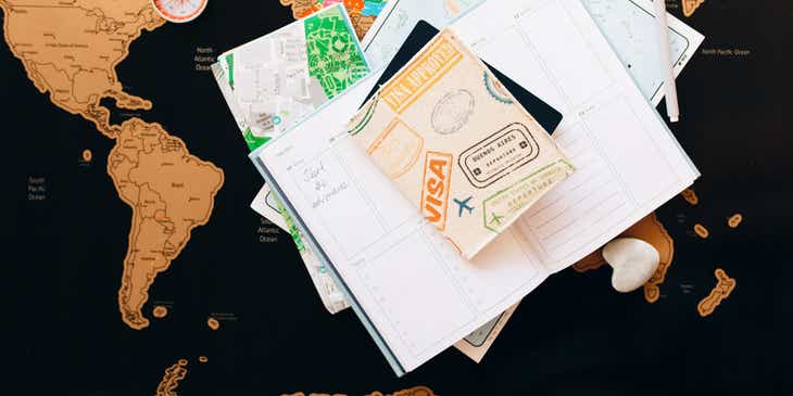 Un pasaporte y una visa que se muestran con un mapa y un diario de viaje en un negocio de trámite de pasaportes y visas.