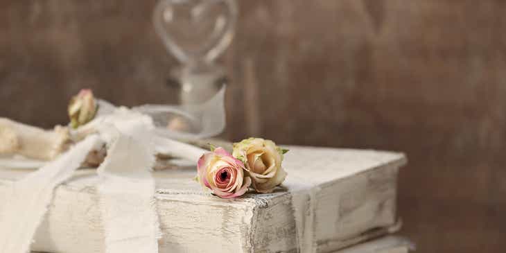 Dried flowers on top of books tied with a white ribbon in a shabby chic style.