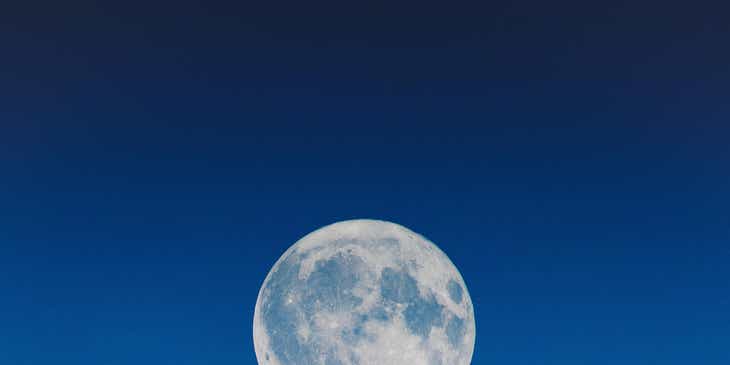 Una romantica vista di un cielo in cui è visibile una grande luna piena.