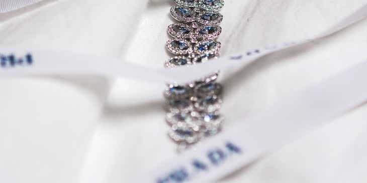 Een hoogwaardige armband gewikkeld in een lint met het logo van een lux merk.