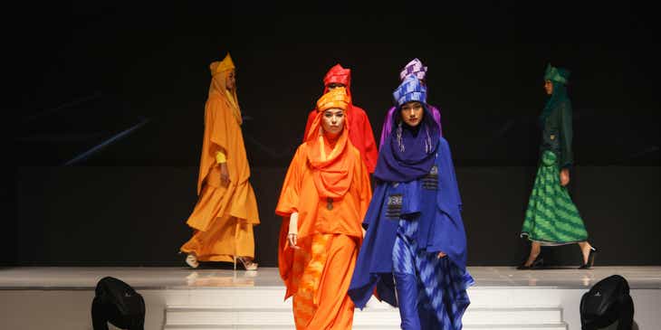 Women wearing modest fashions on the catwalk.