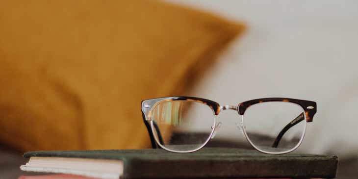 Sepasang kacamata nerd di atas buku.