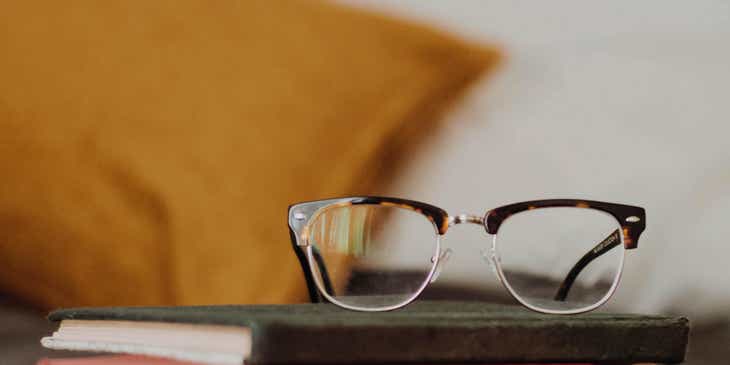 Un paio di occhiali nerd sistemati su una pila di libri.