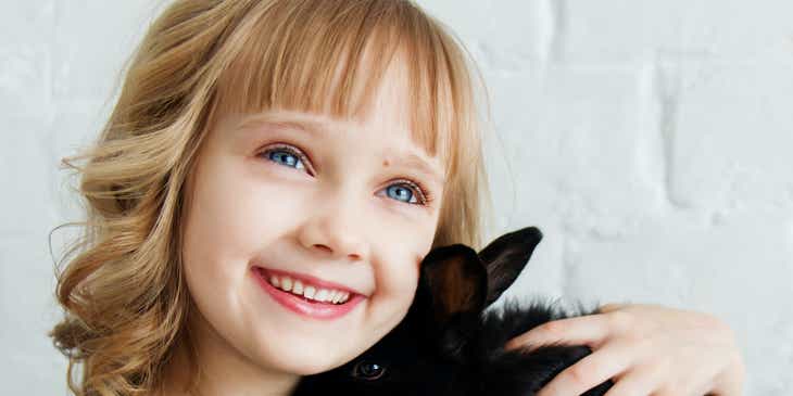 Una agradable imagen de una niña y un conejo.
