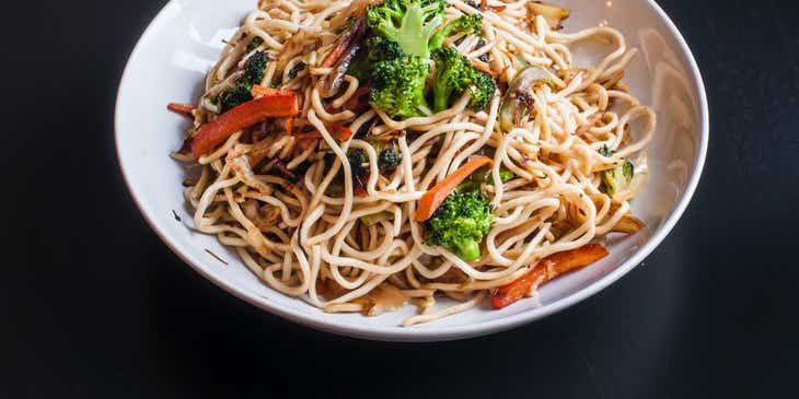 Uma tigela de noodles com legumes em um restaurante de noodles.