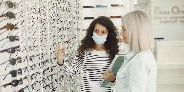 An optician advising a customer on eyewear frames.