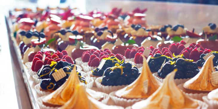 Rows of tarts and pastries on display in a patisserie.