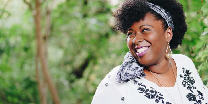 A plus-size fashion model smiling during a photoshoot.