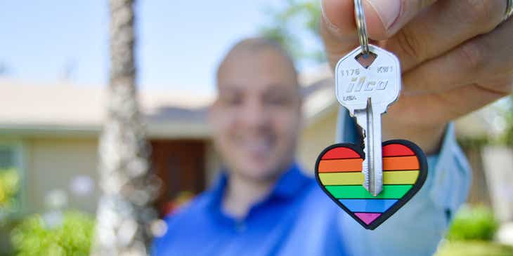Un hombre sosteniendo la llave de una propiedad recién comprada a una empresa inmobiliaria, en un logo para inmobiliarias.