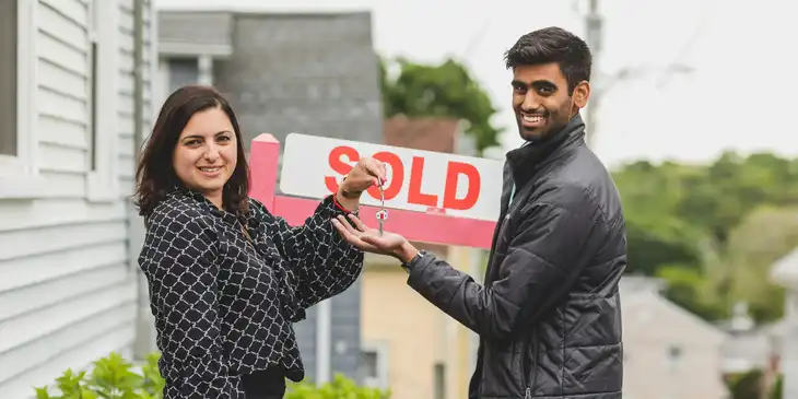 A real estate agent handing keys to her client.